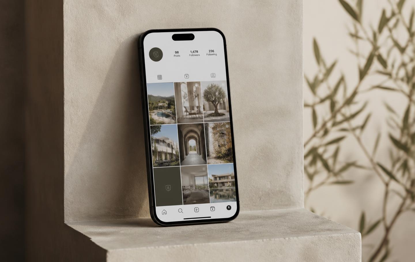 Phone on a plaster ledge showing a property brand social feed managed by the studio